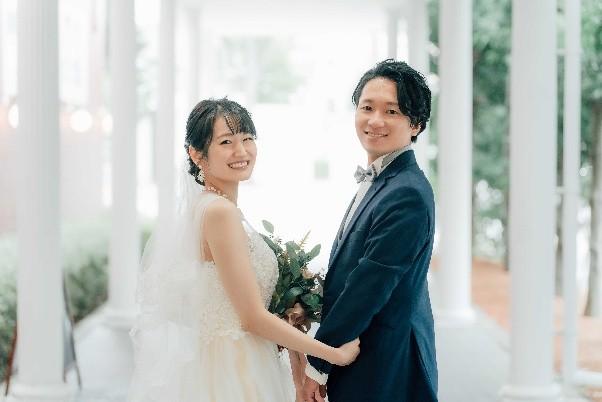 ウエディングドレスとタキシードを着た新郎新婦の画像